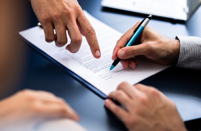 lawyer is showing client where to sign document