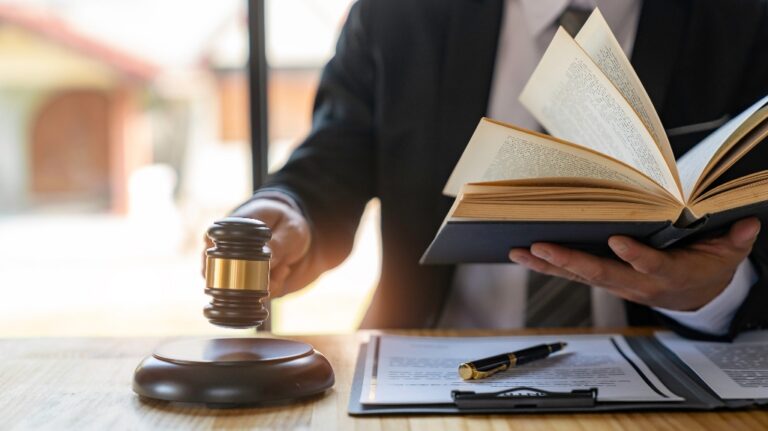 Lawyer is holding judge's gavel and reading law book