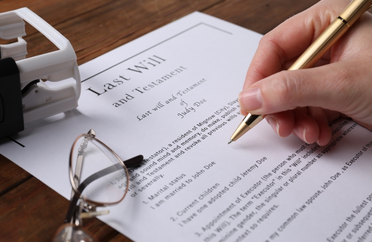 Woman signing Last Will and Testament at wooden table, closeup picture