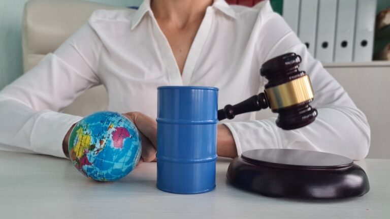 Judge gavel, oil barrel with gasoline and globe in court
