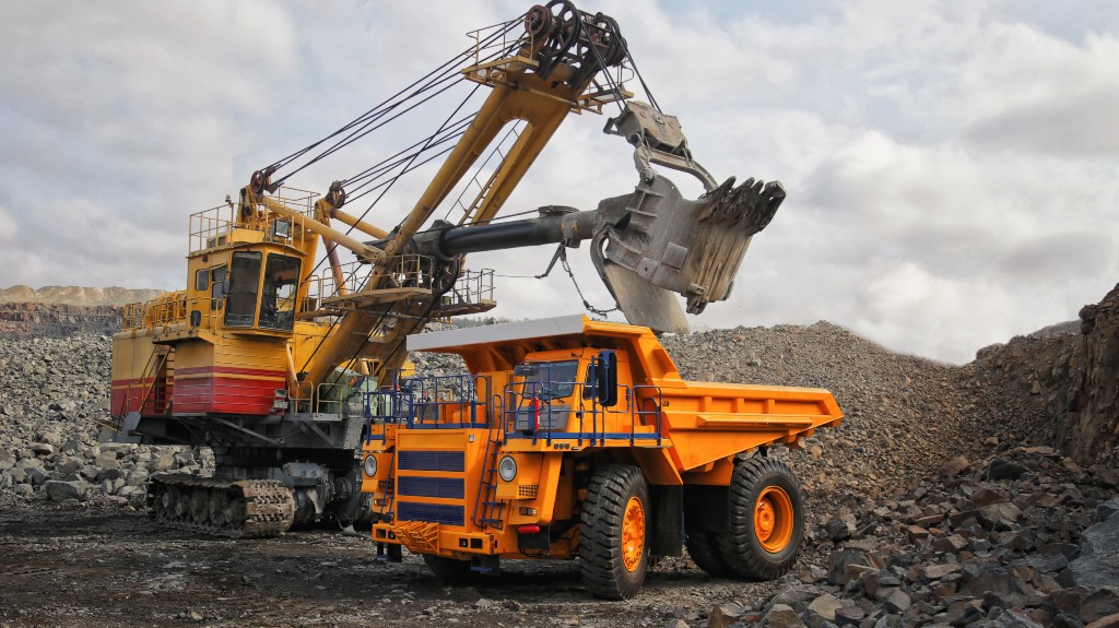 Digger loading dump truck with iron ore