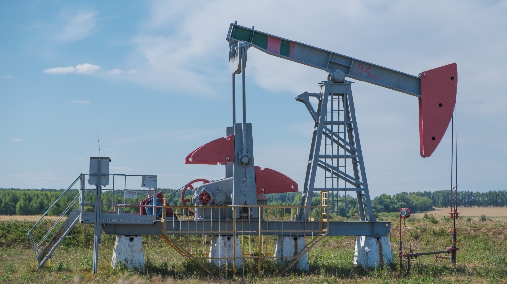 Oil Pumpjack in Rural Landscape Under Blue Sky